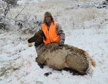 Cow elk hunter posing in the snow after the hunt